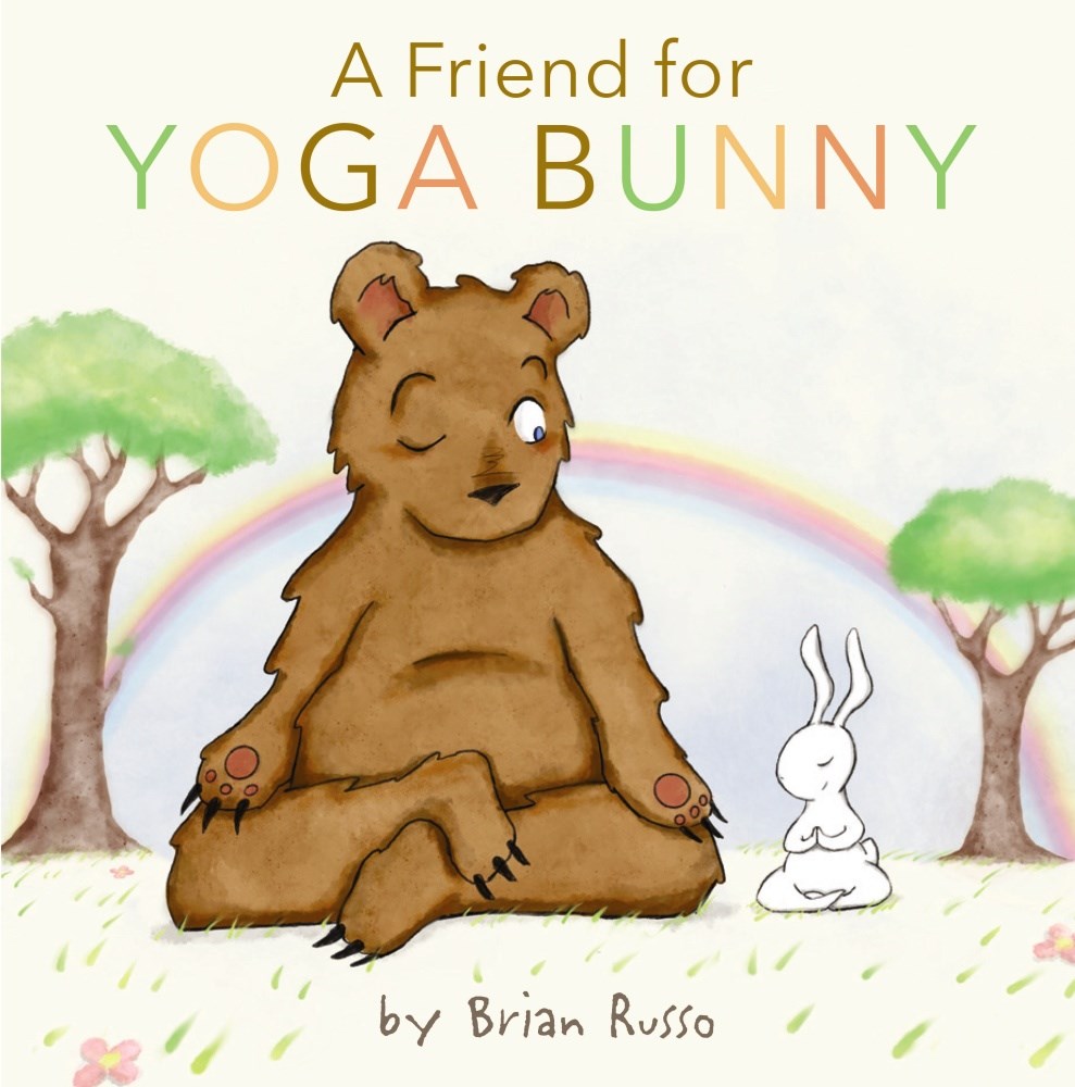 A small white rabbit sits cross-legged in a field of grass with his eyes closed. Next to him, a large brown bear is sitting much the same - but he's peeking one eye open to look at the bunny. Behind them a rainbow and two trees grace the scene. Text: "A Friend for Yoga Bunny"