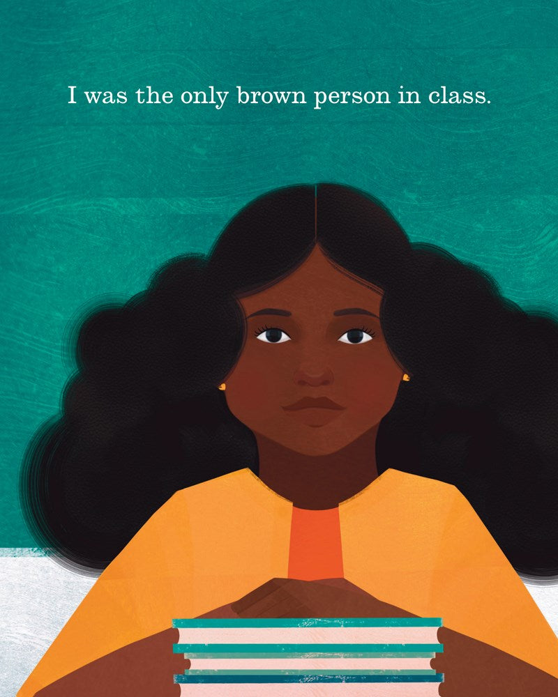 A young Black girl sits with her hands folded across a stack of books. " I was the only brown person in class"