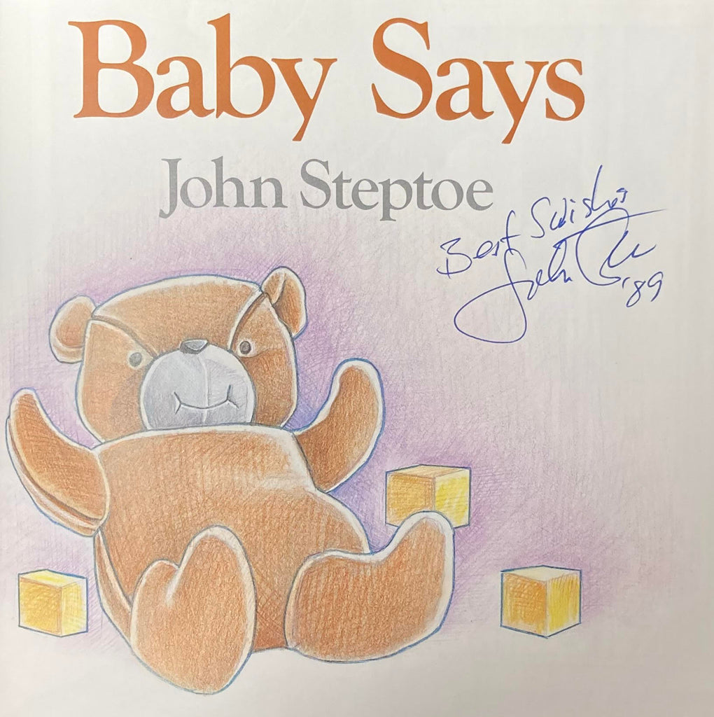 Image of the title page of Baby Says by John Steptoe. The author's signature is right below his printed name and dated 1989. Image shows a teddy bear and three yellow wooden blocks. 